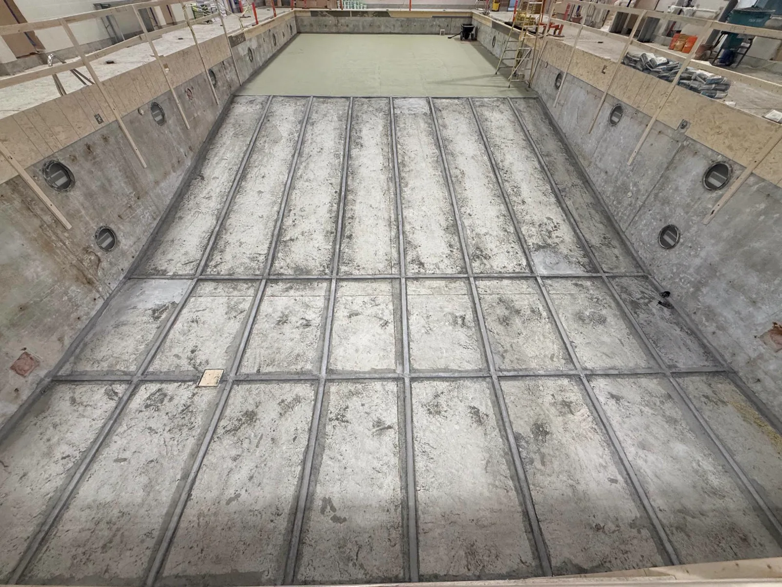 Grid of mortar screed rails across the pool floor