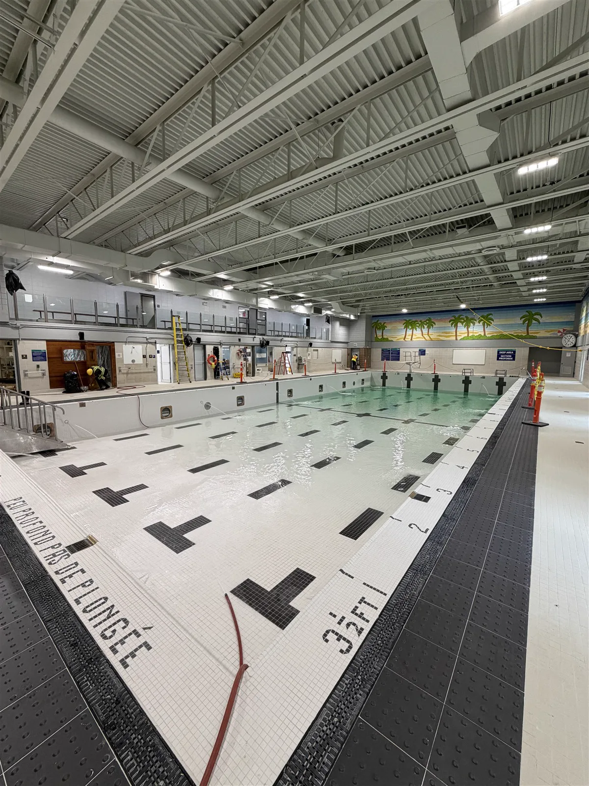 Pool deck with black depth markings set in tile
