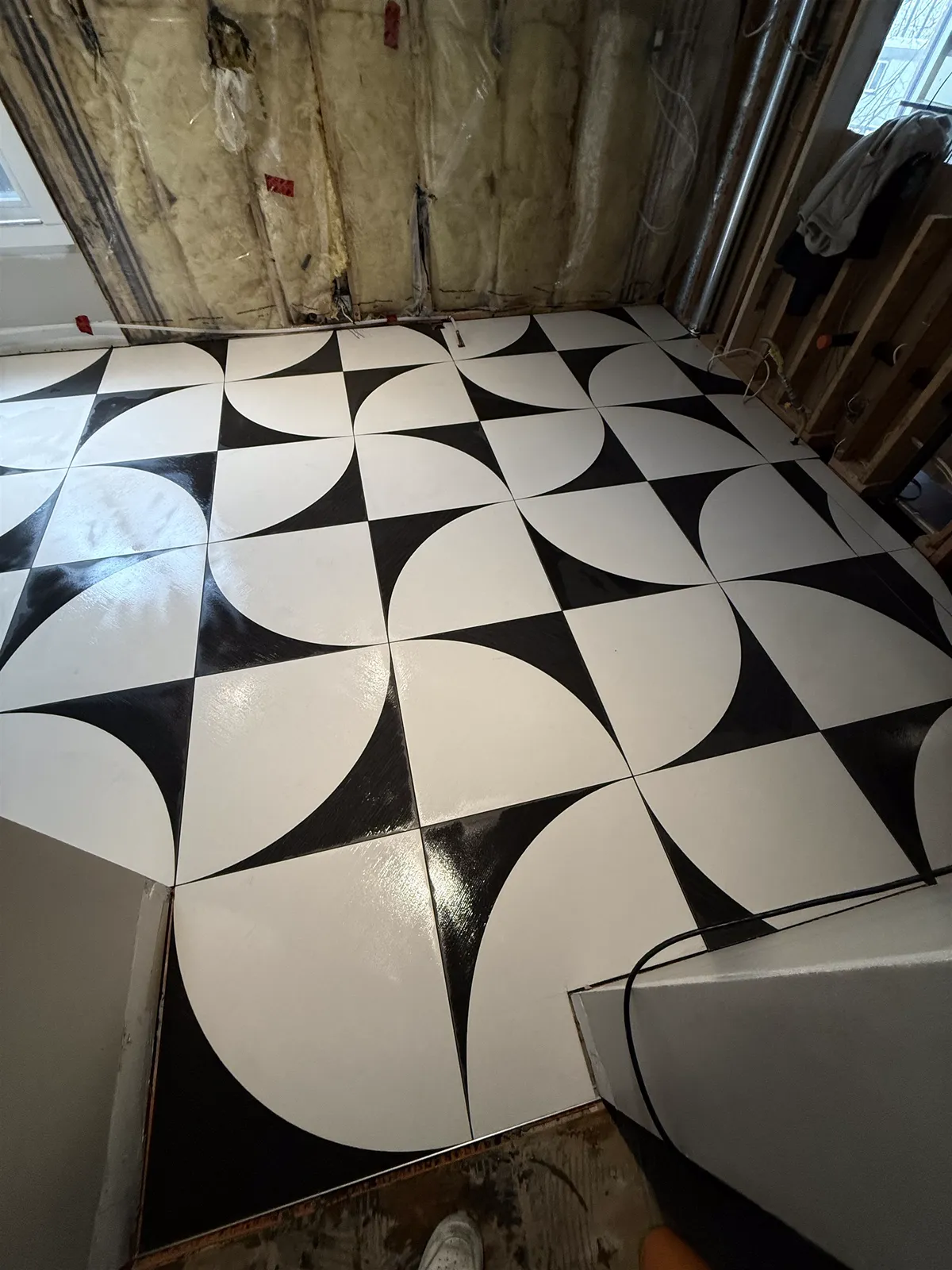 Black and white porcelain floor laid in a quarter-circle pattern