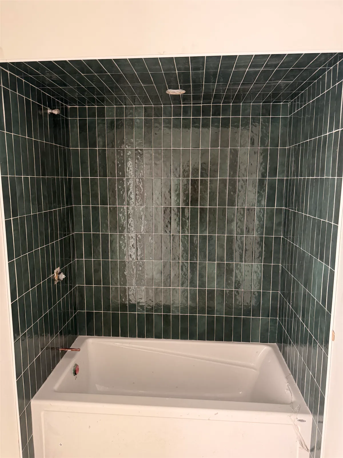 Tub surround in handmade-look emerald green glazed tile