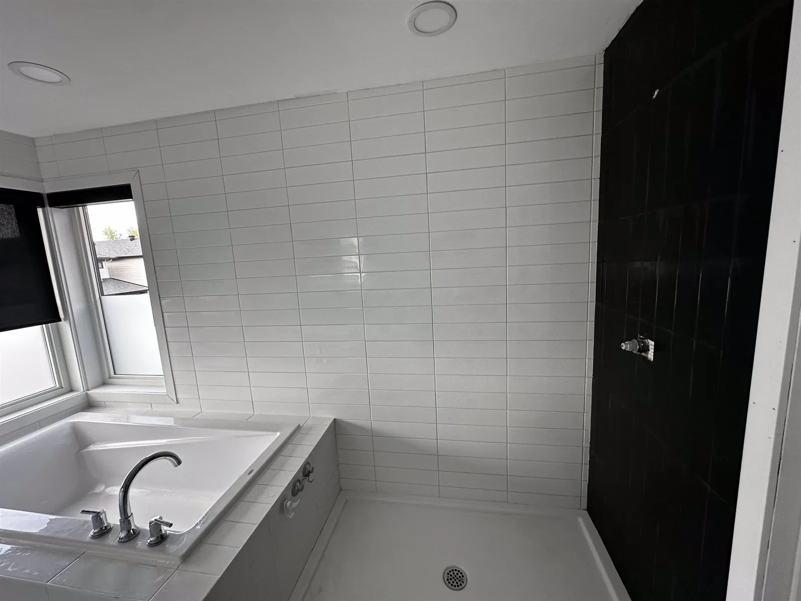 White bathroom with a black tile accent wall