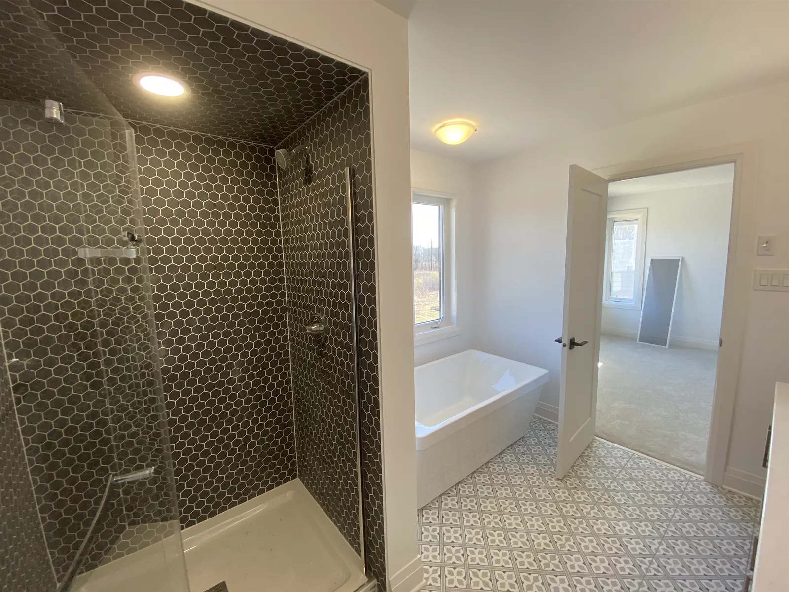 Shower tiled floor to ceiling in black hexagon mosaic